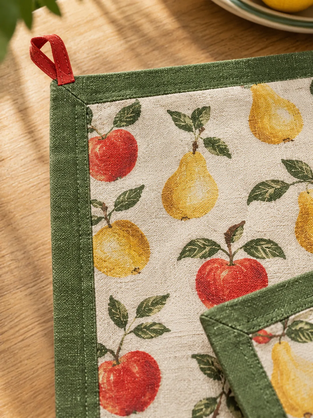 Orchard Print Tablecloth close up: edge finish and red corner loop