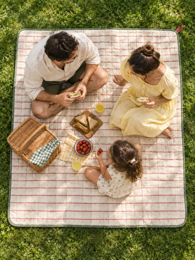 Quilted Picnic Mat with Carry Strap on a laid weekend table